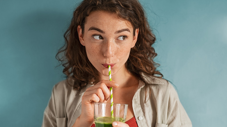 Woman sipping smoothie with straw
