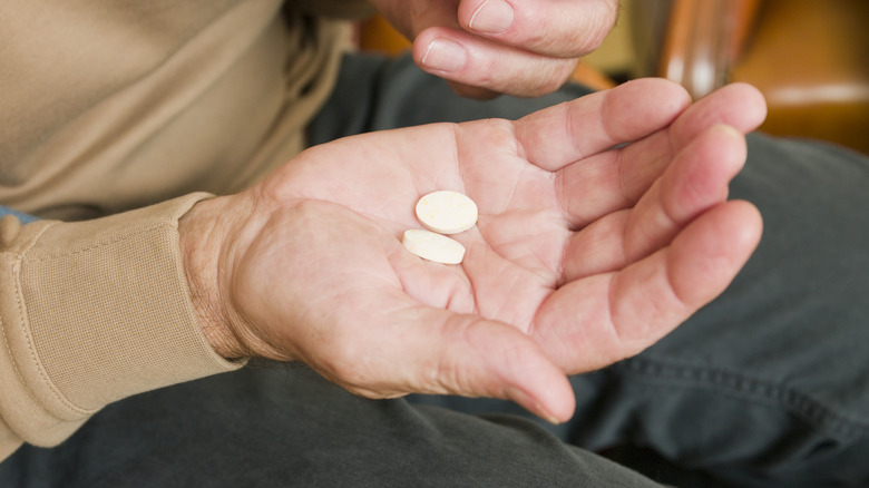male hands holding medicine pills