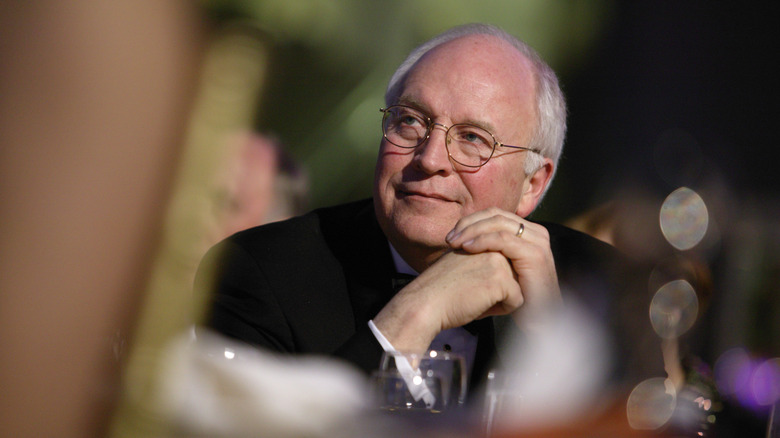 Dick Cheney looking pleased clasping his hands
