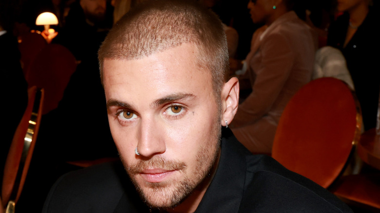 Close shot of Justin Bieber at the 2026 Grammys showing a straight and cropped hairline on his forehead, suggesting a hair transplant.