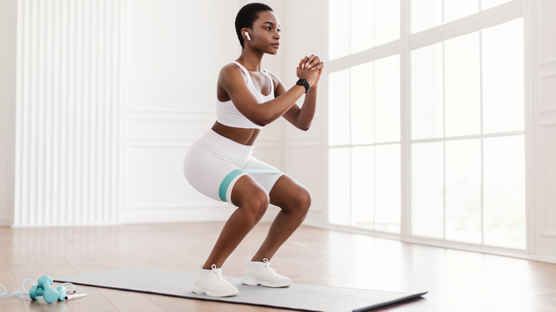 Woman squatting at gym