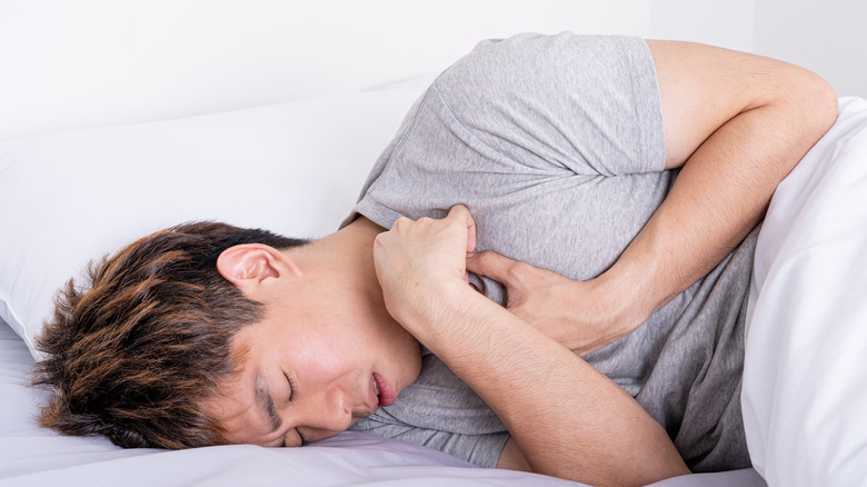 Man lying in bed suffering from acid reflux