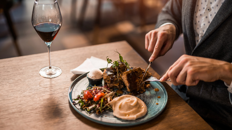man cutting steak at a restaurant