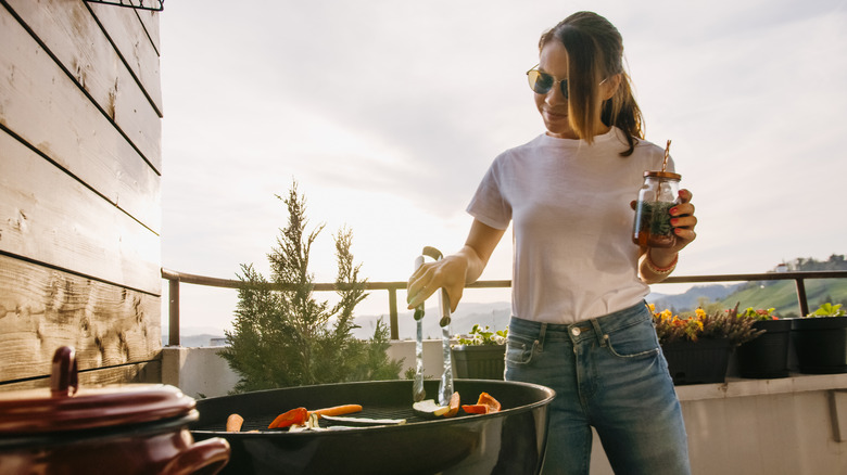 woman cooking steak on a grill