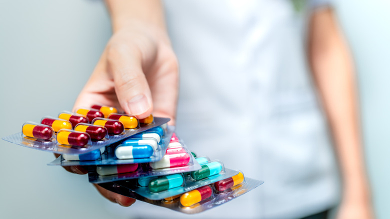 Hand holding packets of capsules