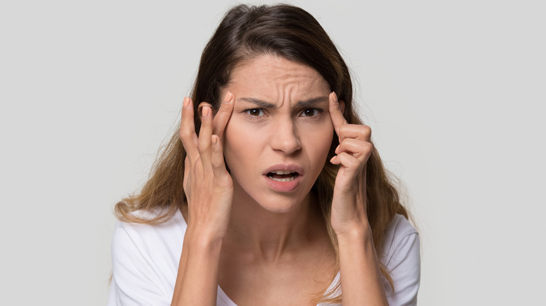 young woman pointing at wrinkles