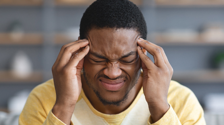 Man scrunching face in pain