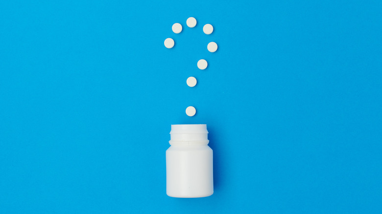 vitamins creating question mark shape above bottle