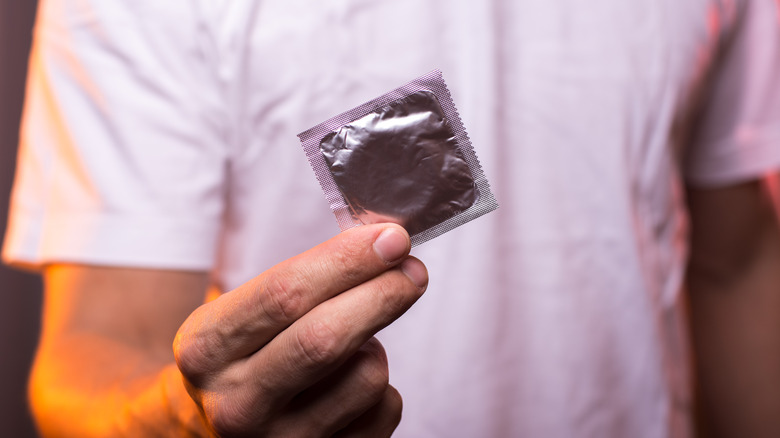 Man holding condom in wrapper 
