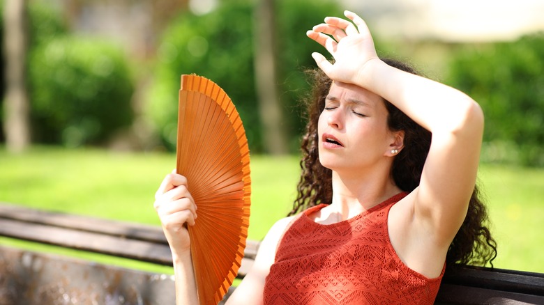 White brunette woman fanning herself in extreme heat