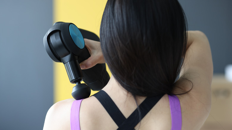 Woman holding massage gun
