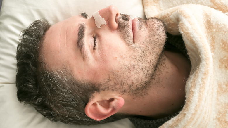 man sleeping with nasal strip on nose
