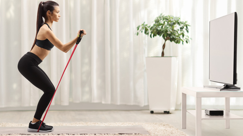 woman using resistance bands at home