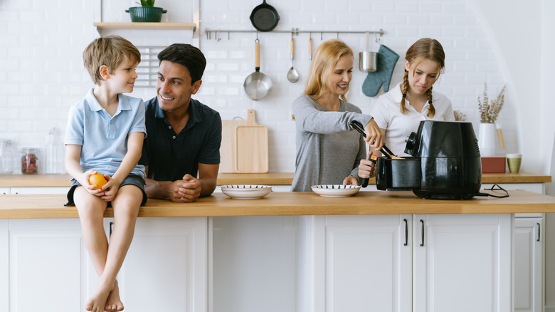 family in kitchen using air fryer