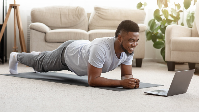 young man planking in his living room 