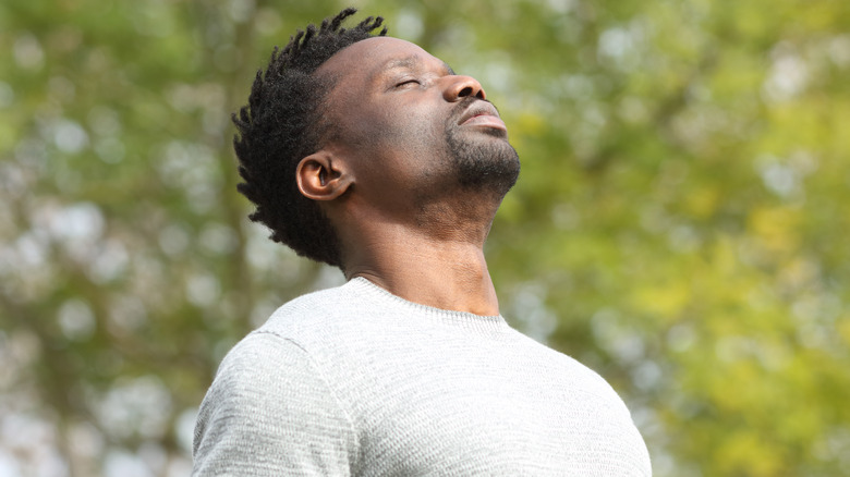 Man breathing deeply outdoors