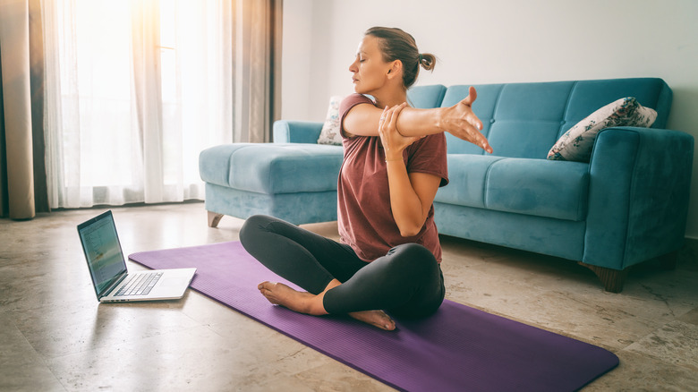 A woman is stretching at home