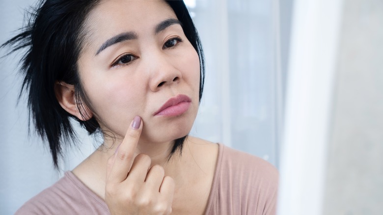 Woman pointing to laugh line on face