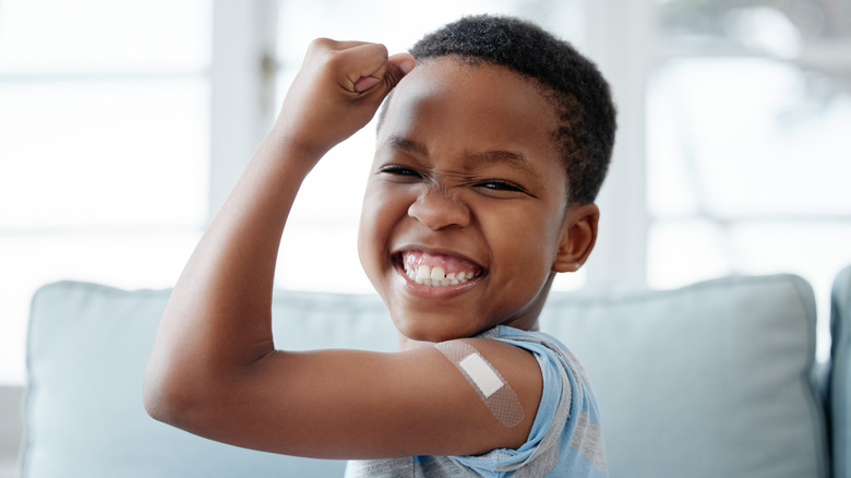 Happy boy with bandaid on arm from vaccination