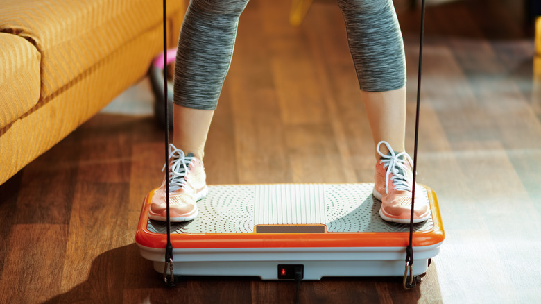 Person standing on vibration plate