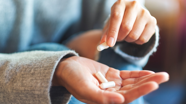 Smiling woman taking vitamin supplement