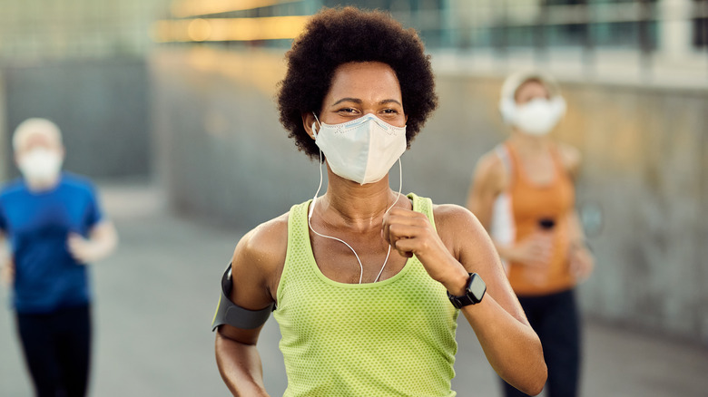 People running outside with masks