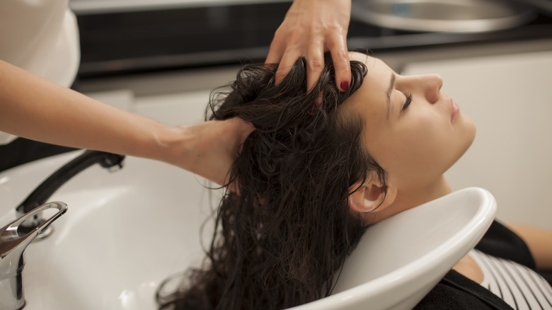 young woman getting a scalp message at a salon 