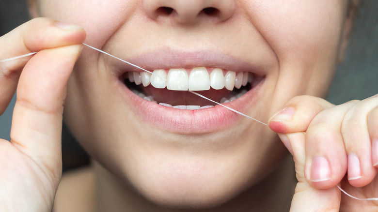 close-up of woman's mouth while flossing
