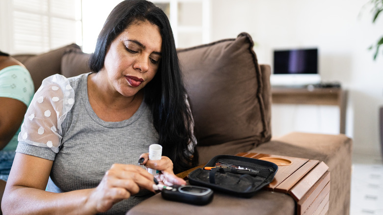 woman checking her blood sugar at home