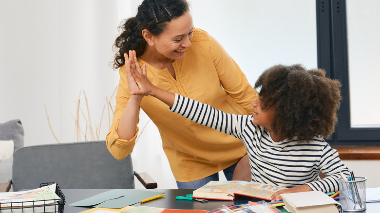 Woman high fives young child