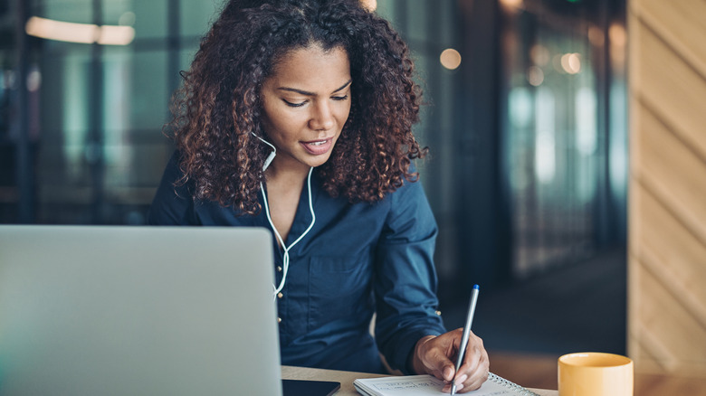 left-handed woman writing in a notebook