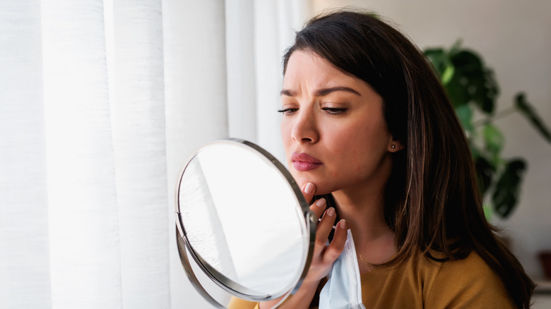 Woman looking at her acne