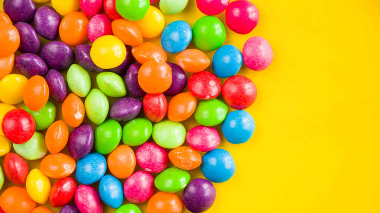 An assortment of colored candies on a yellow background