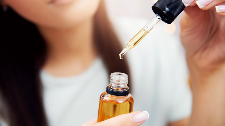 Woman holding a bottle of castor oil