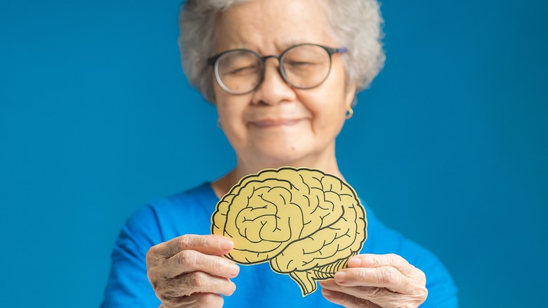 mature woman holding paper brain