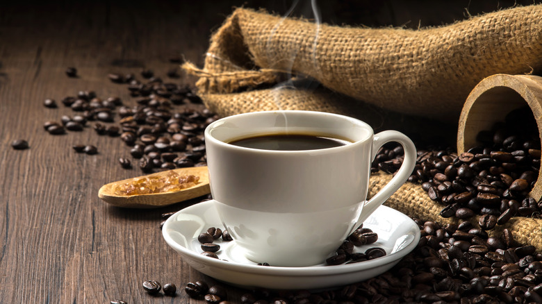 hot coffee with beans on table