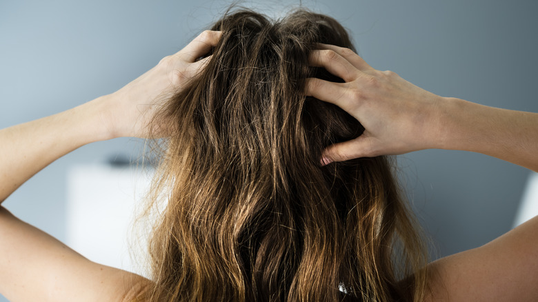 woman scratching hair while stressed