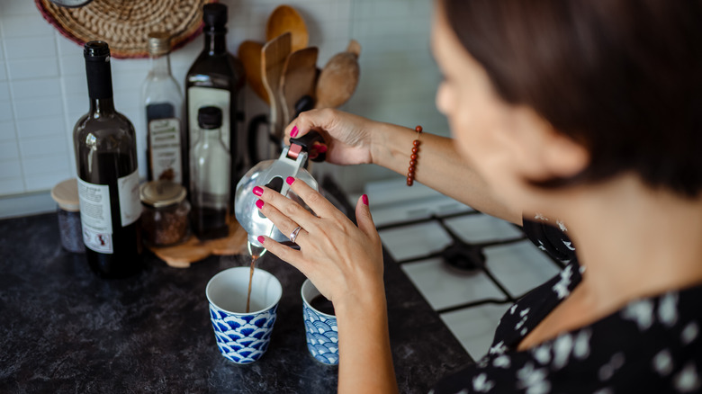 Woman pouring coffee into mug