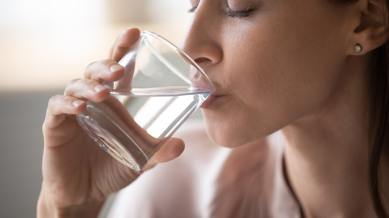 woman drinking water from glass