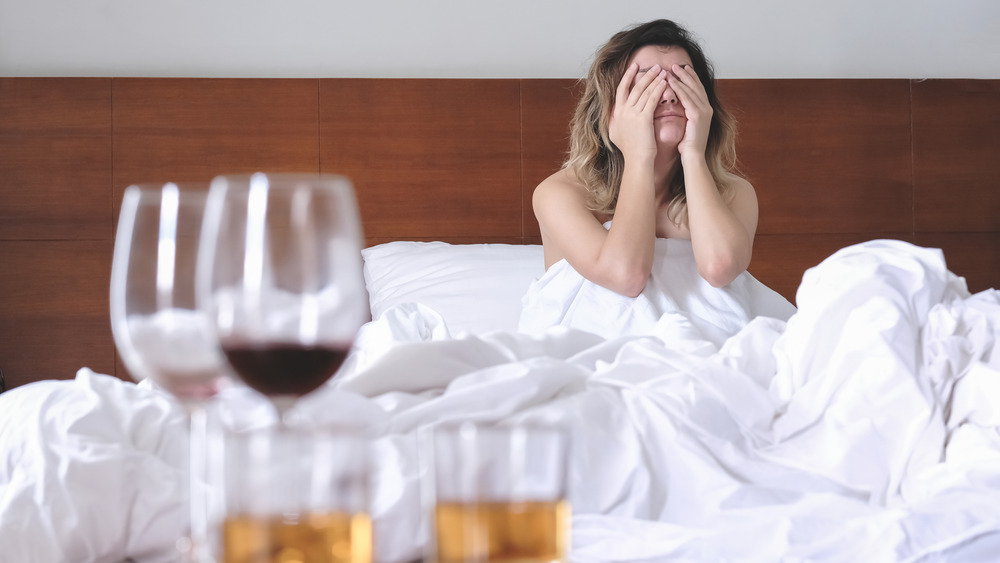 Hungover woman looking at more alcohol
