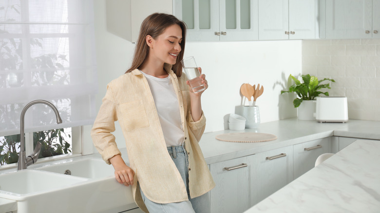 A woman drinks a cup of water