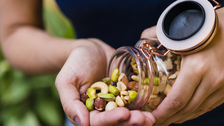 man pouring out a handful of nuts