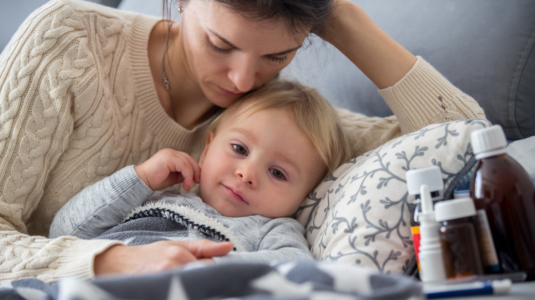 Mom laying in bed with sick toddler