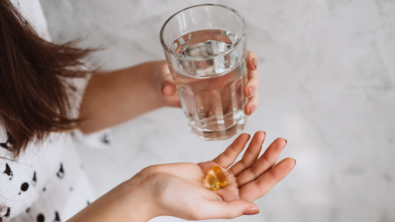 A woman takes fish oil supplements