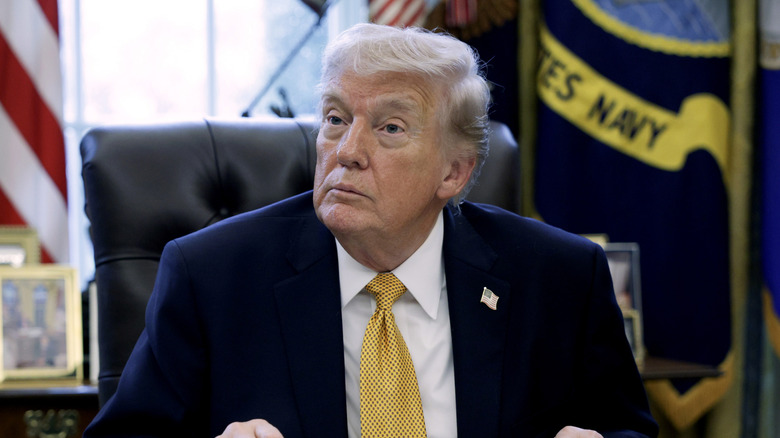 Donald Trump preparing to sign paperwork in the White House Oval Office