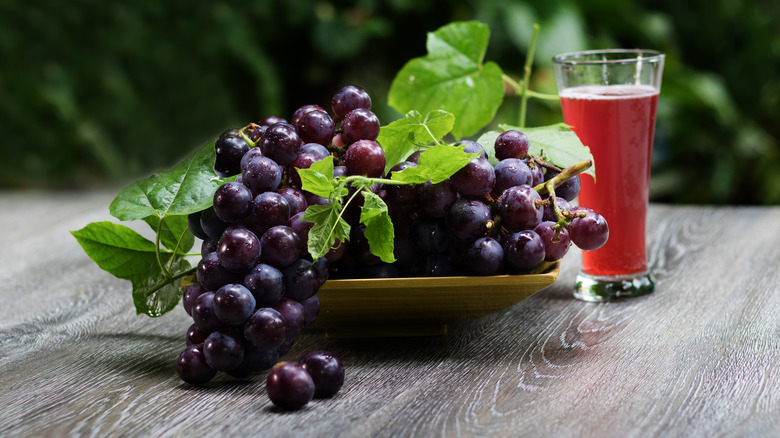 grapes on table with a glass of grape juice