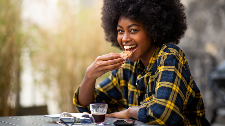 woman eating cookie and smiling