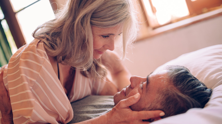 Mature couple cuddling on bed