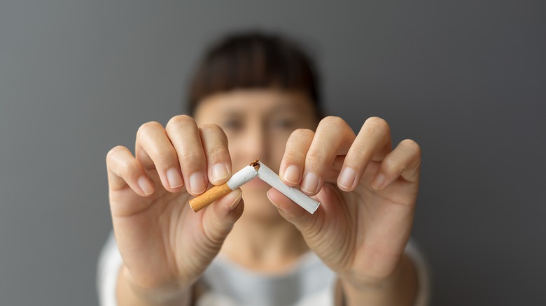 Woman snapping cigarette in half