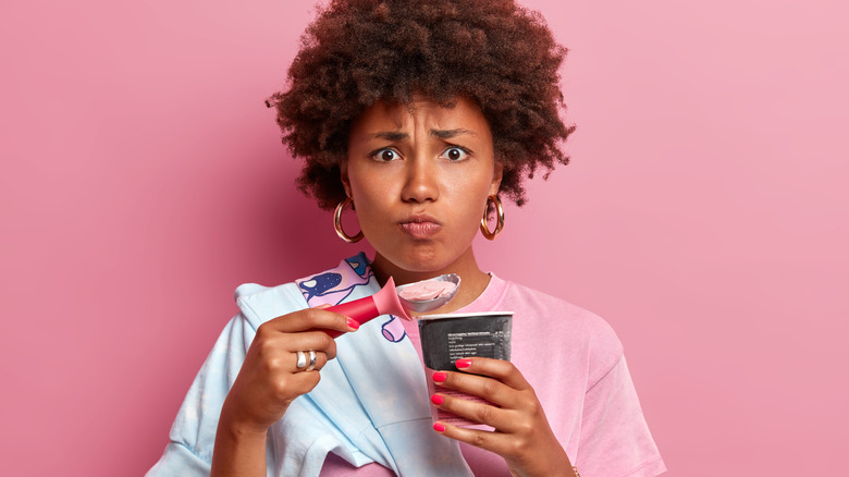 Woman with worried look eating ice cream